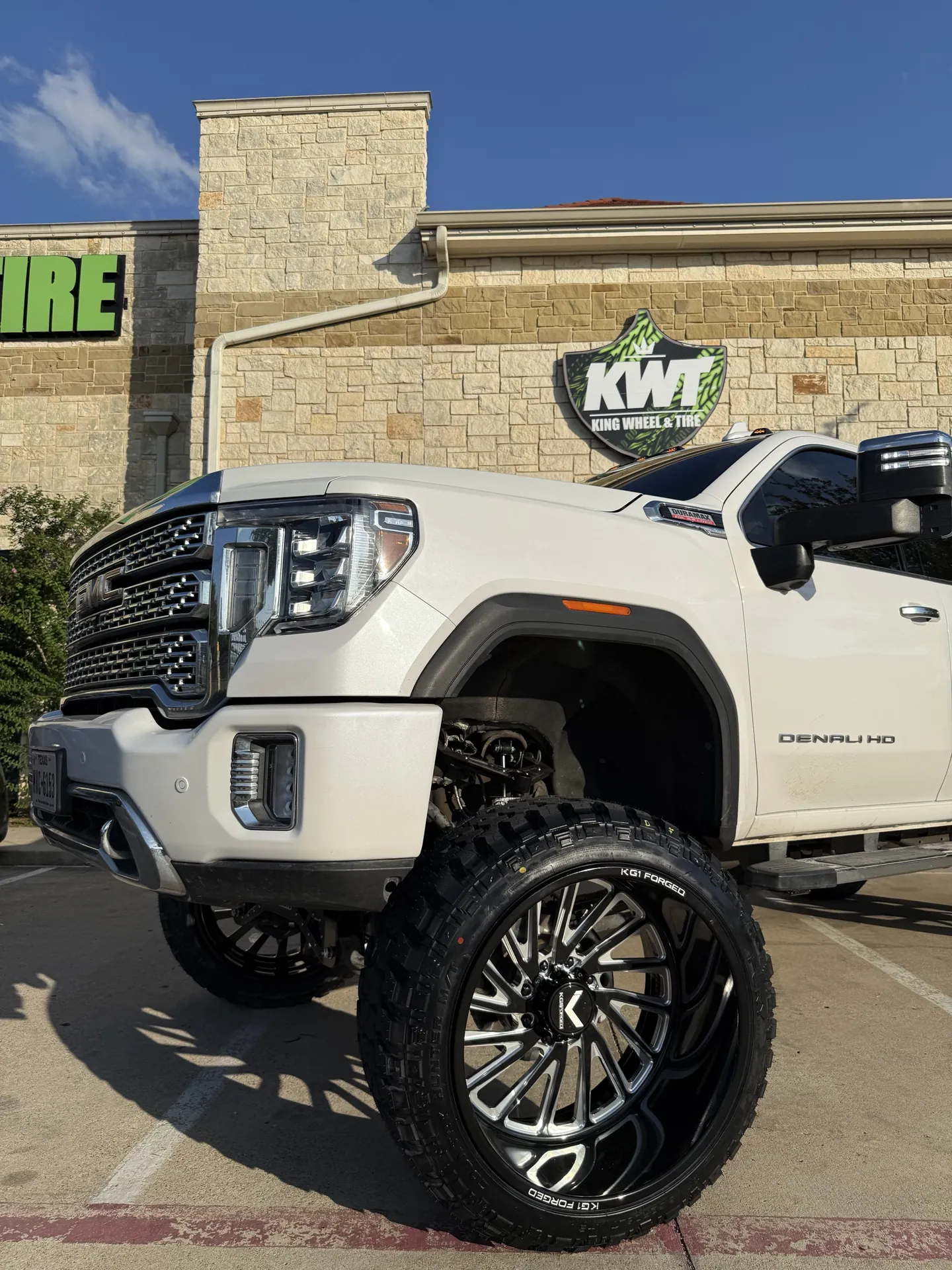 A forged wheel and mud-terrain tire on a lifted GMC Denali HD
